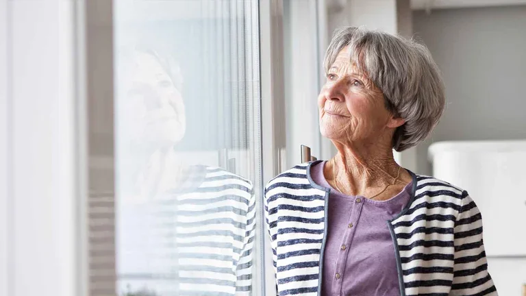 Patientin der Heimparenteralen Therapie schaut aus dem Fenster