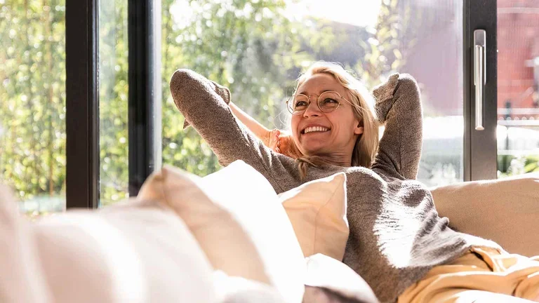 Patientin mit pulmonaler arterieler Hypertonie sitzt auf dem Sofa