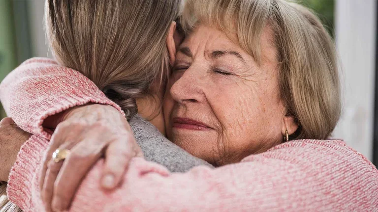 Patientin mit Schmerztherapie umarmt Angehörige