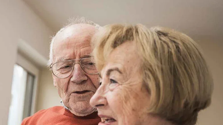 Patientin Schmerztherapie (PCA) mit ihrem Mann auf den Sofa im Gespräch