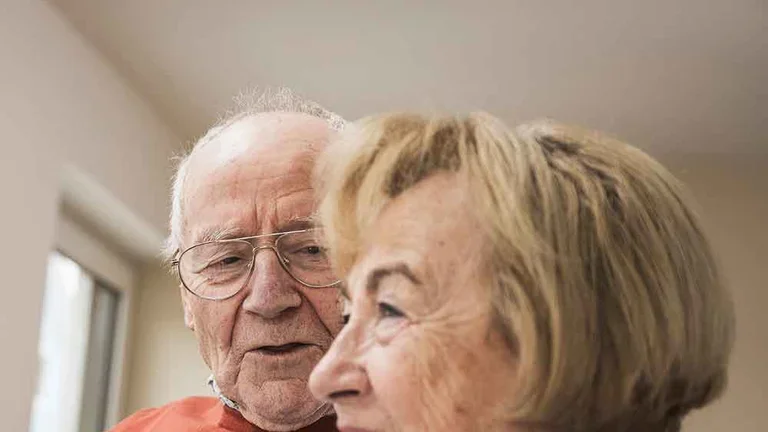 Patientin Schmerztherapie (PCA) mit ihrem Mann auf den Sofa im Gespräch
