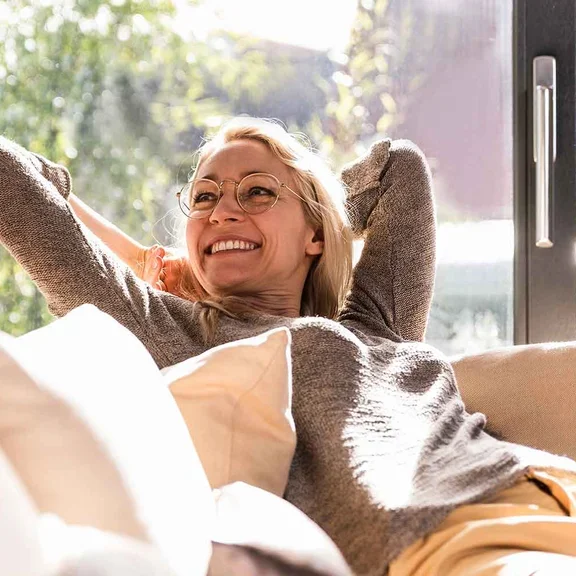 Patientin mit pulmonaler arterieler Hypertonie sitzt auf dem Sofa